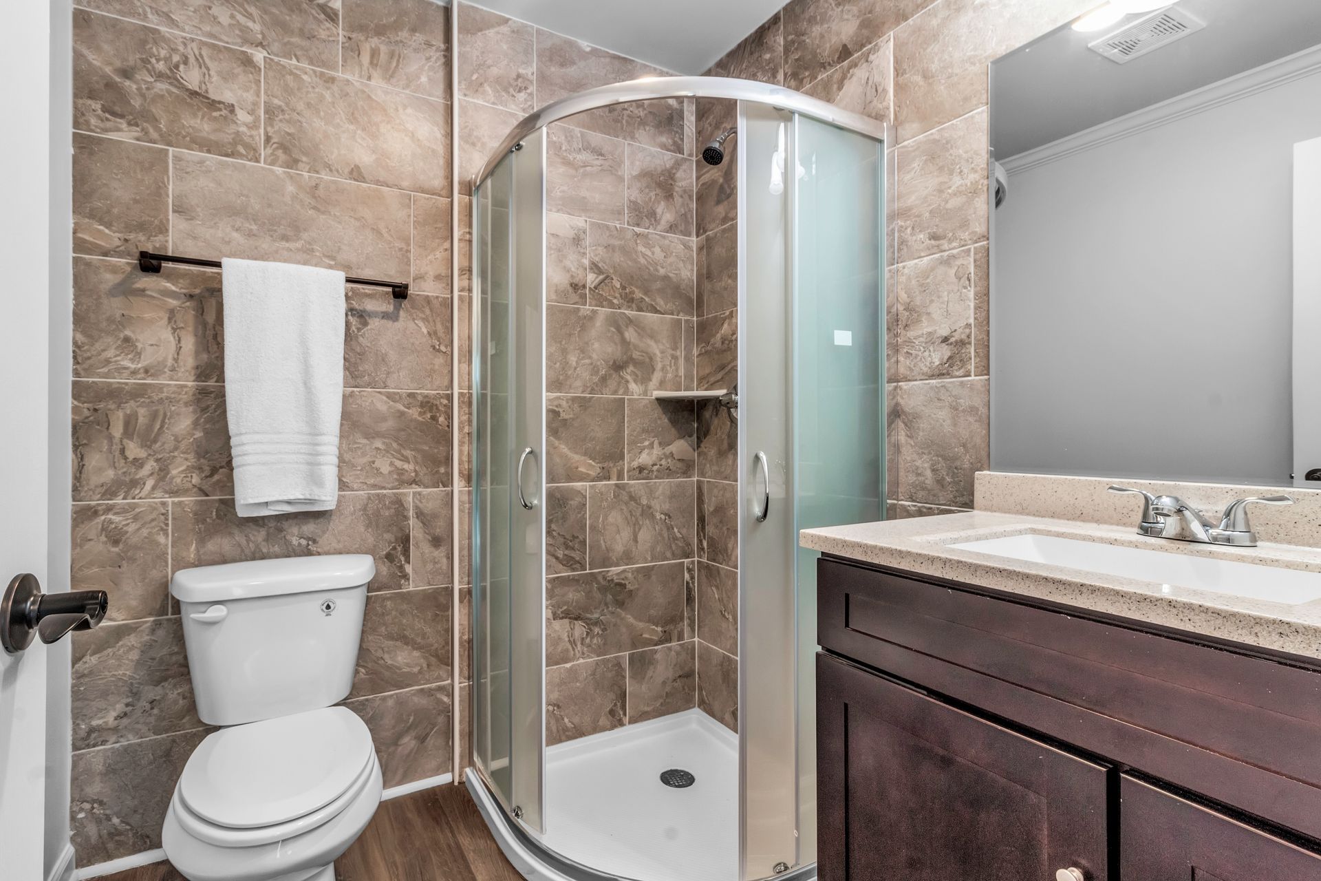 A bathroom with a toilet , sink , and shower stall.