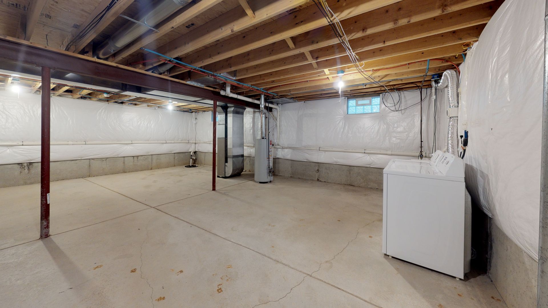 A basement with a washer and dryer in it.