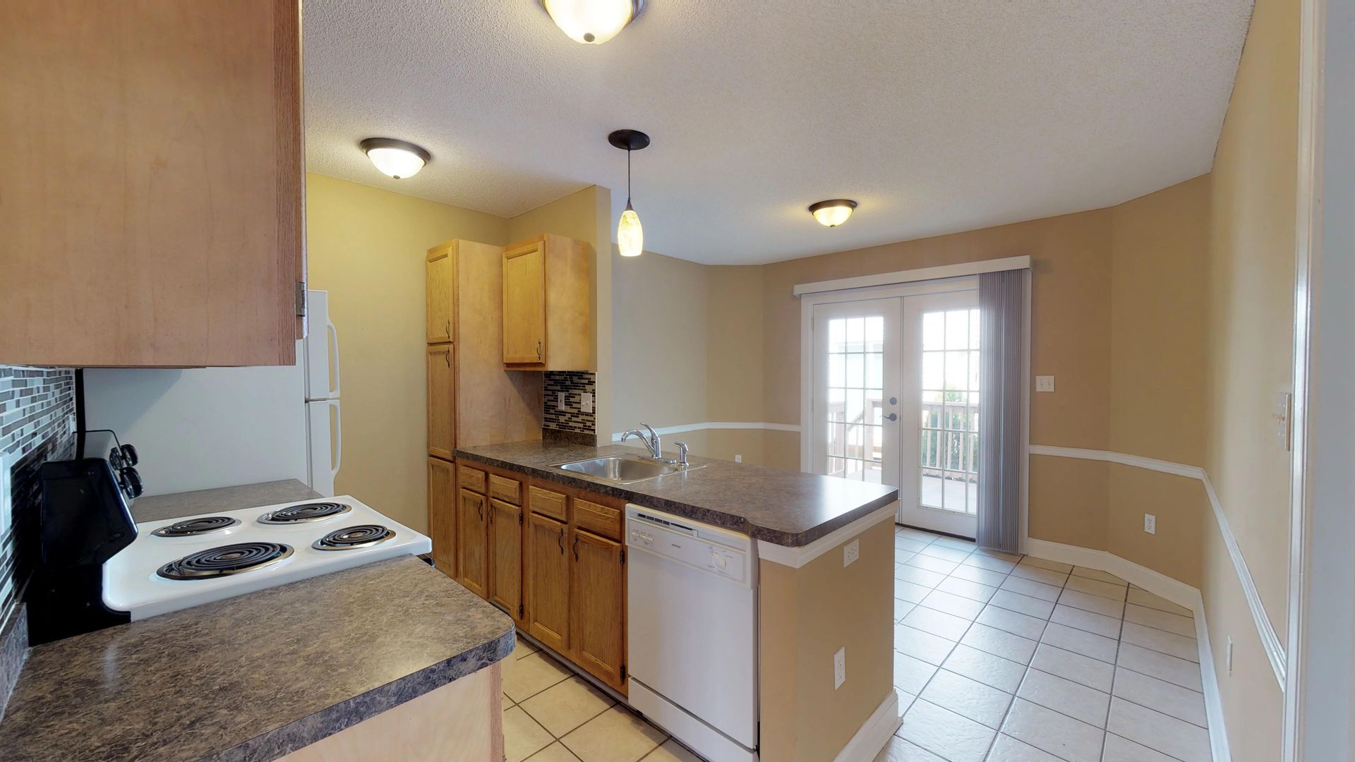 A kitchen with a stove , sink , and dishwasher.