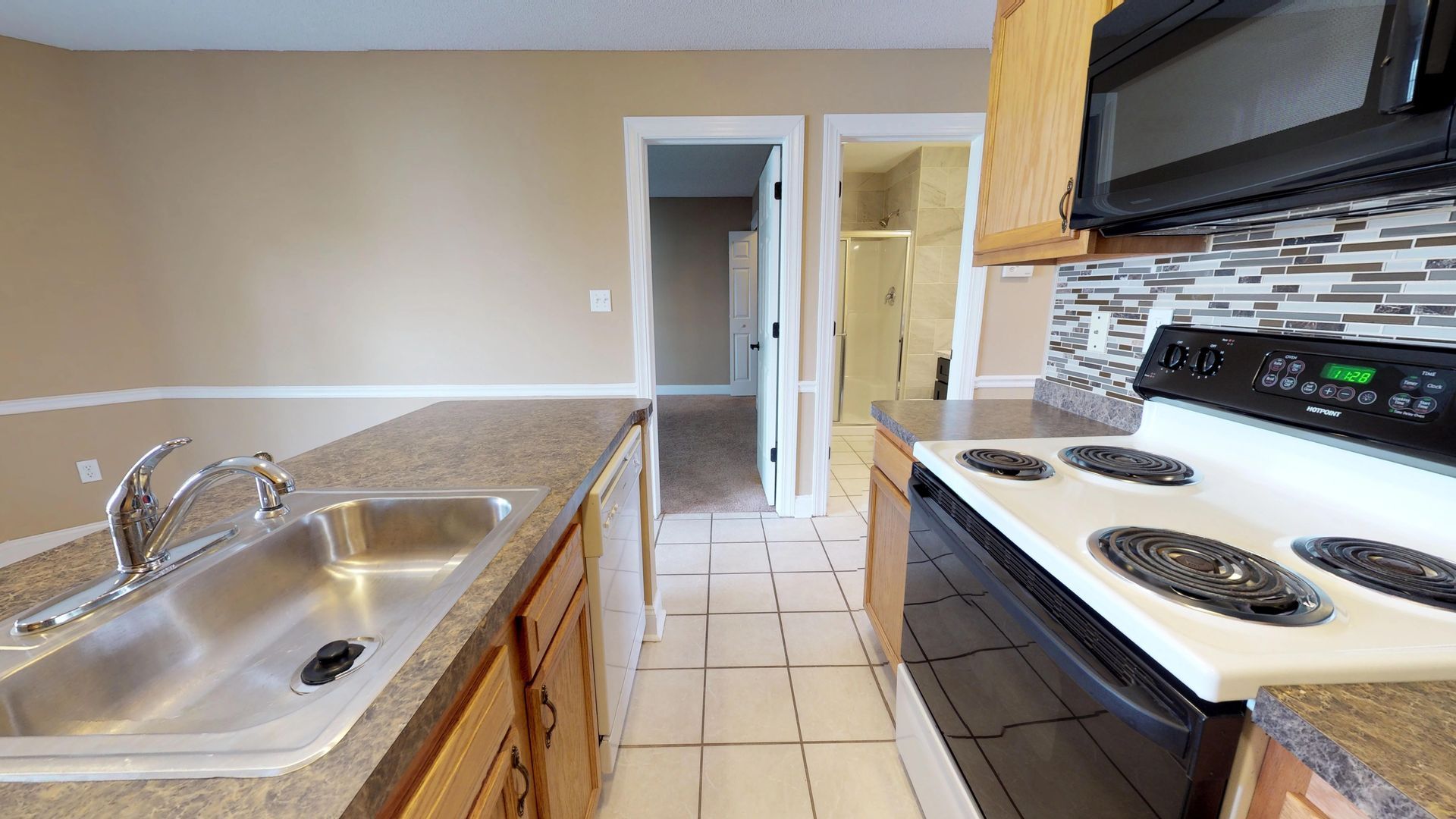 A kitchen with a sink , stove , and microwave.