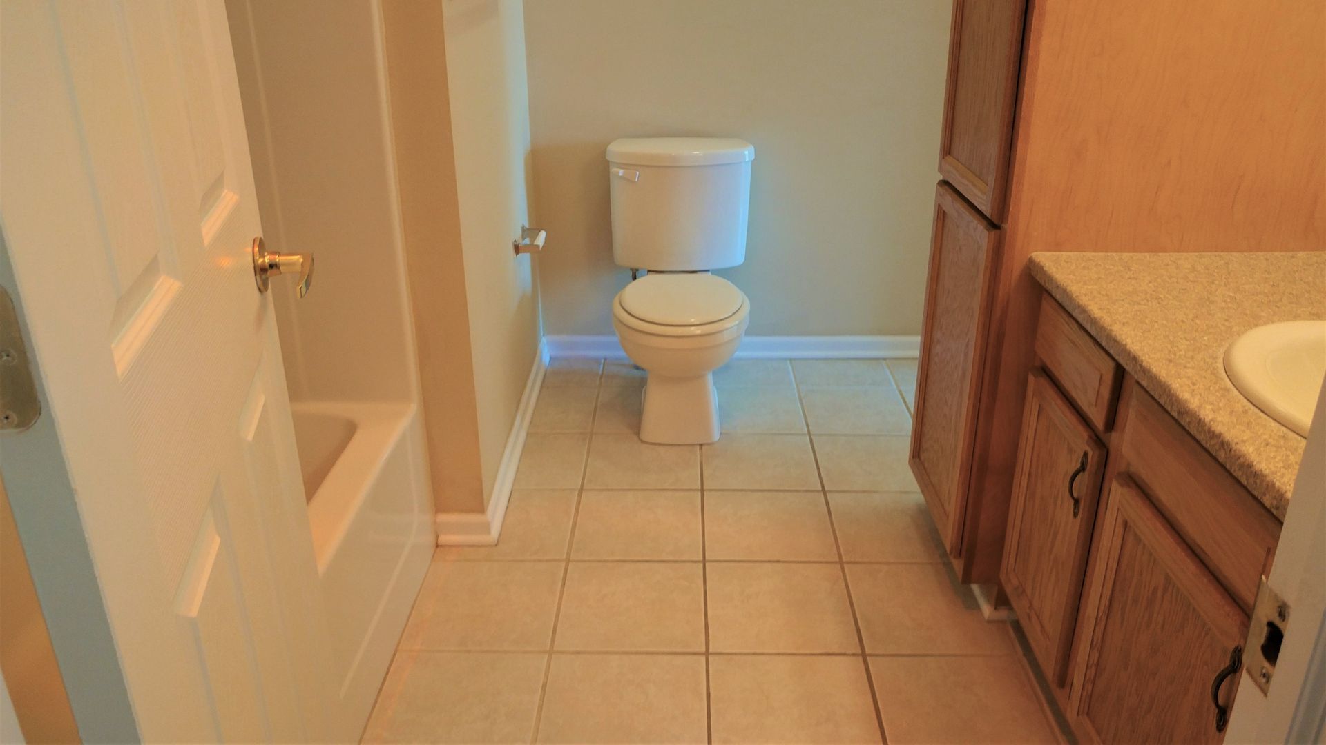A bathroom with a toilet , sink , and bathtub.
