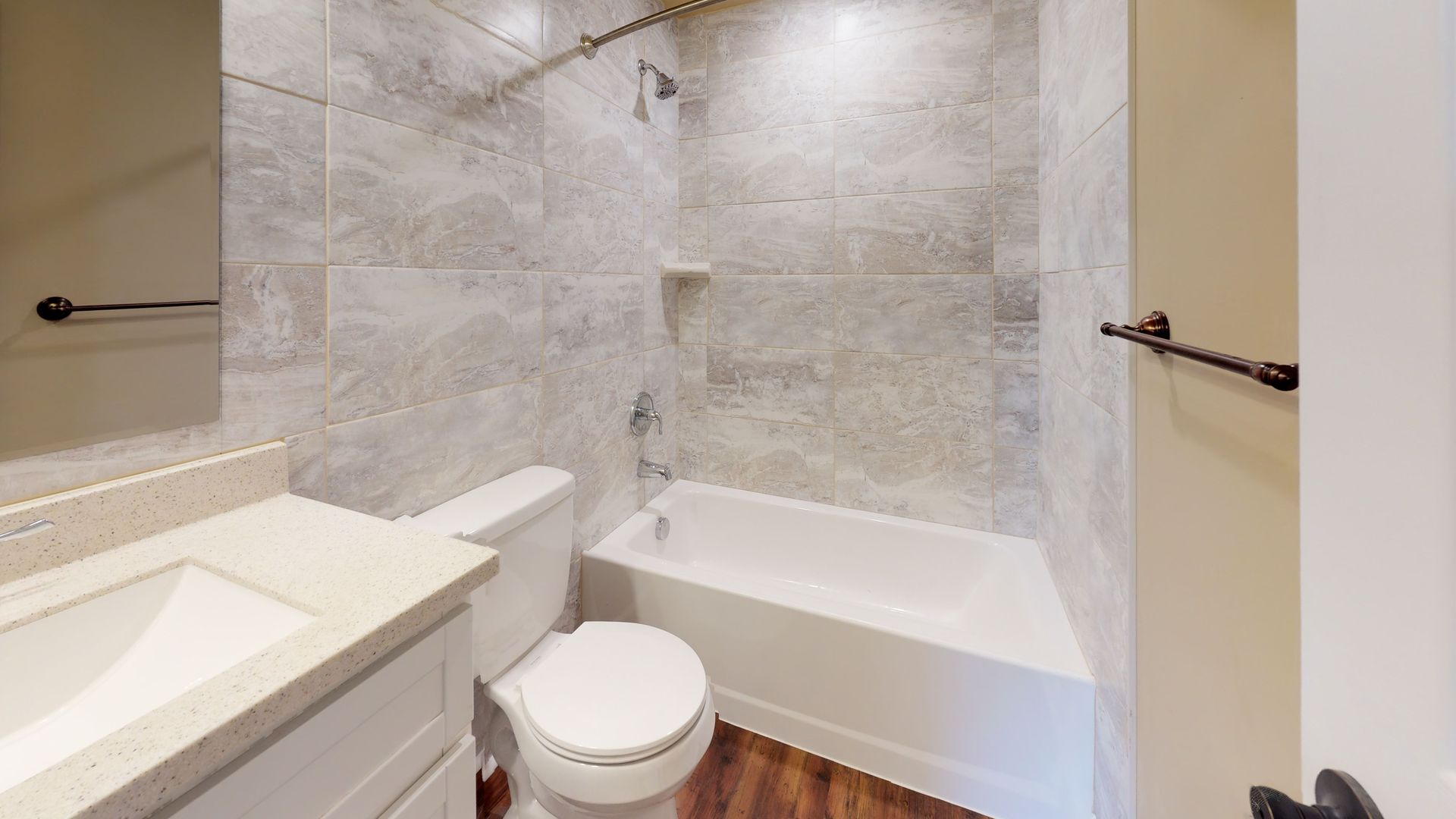 A bathroom with a toilet , sink , and bathtub.