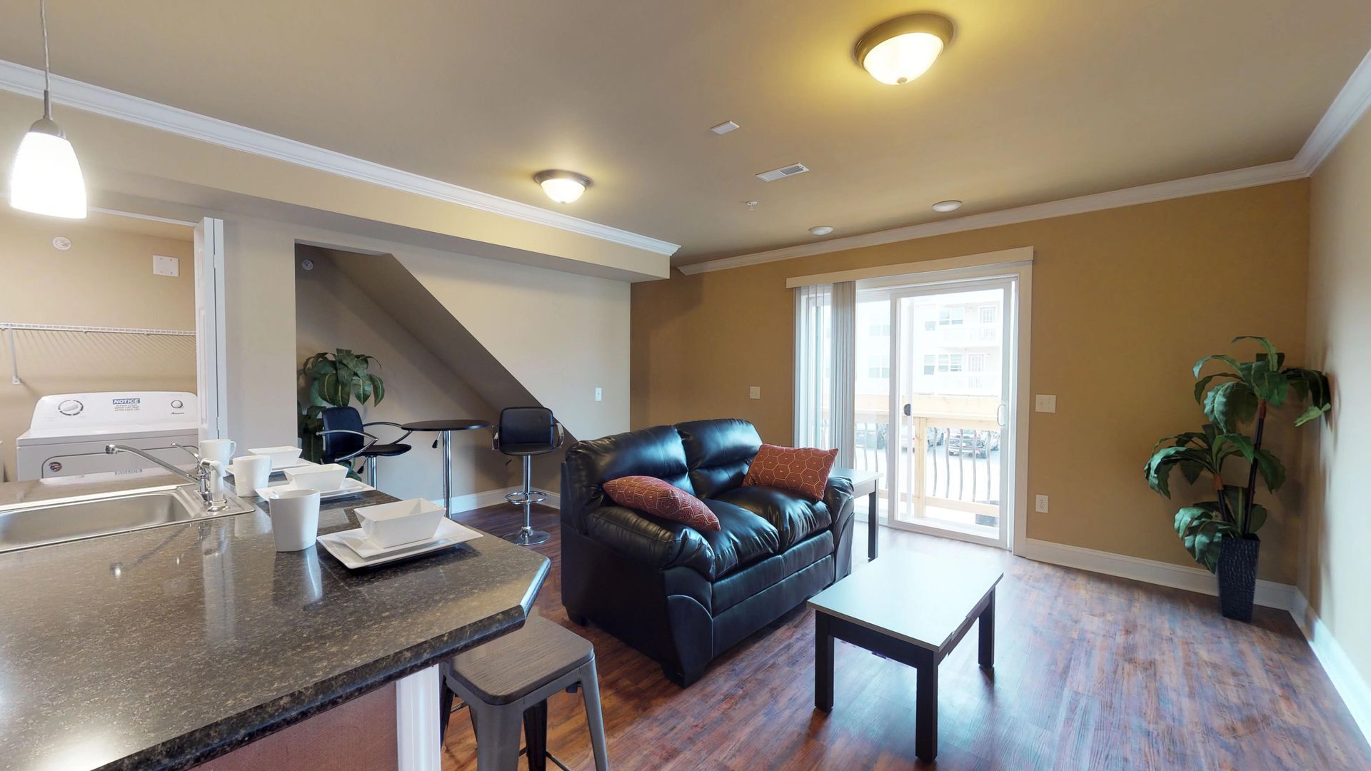 A living room with a couch , coffee table , and sliding glass doors.