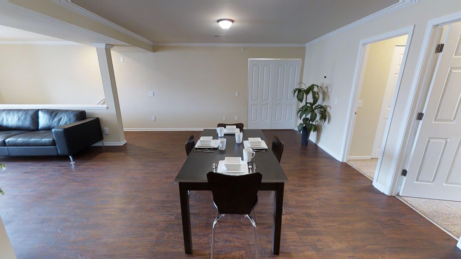 A living room with a table and chairs and a couch.