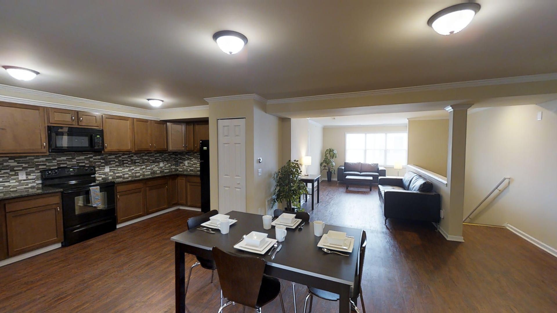 There is a table and chairs in the middle of the room.
