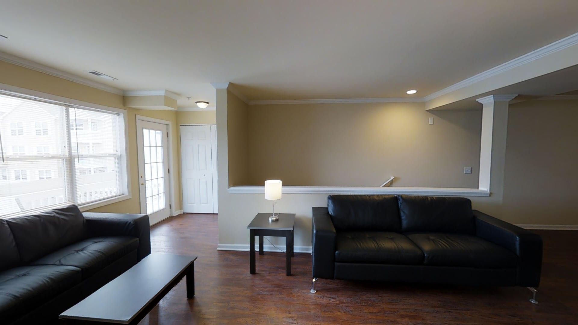 A living room with two couches , a coffee table , and a lamp.