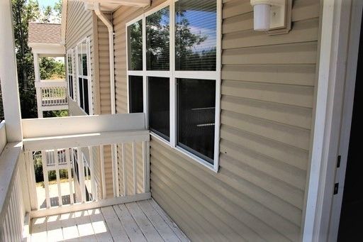 A porch with a white railing and a lot of windows