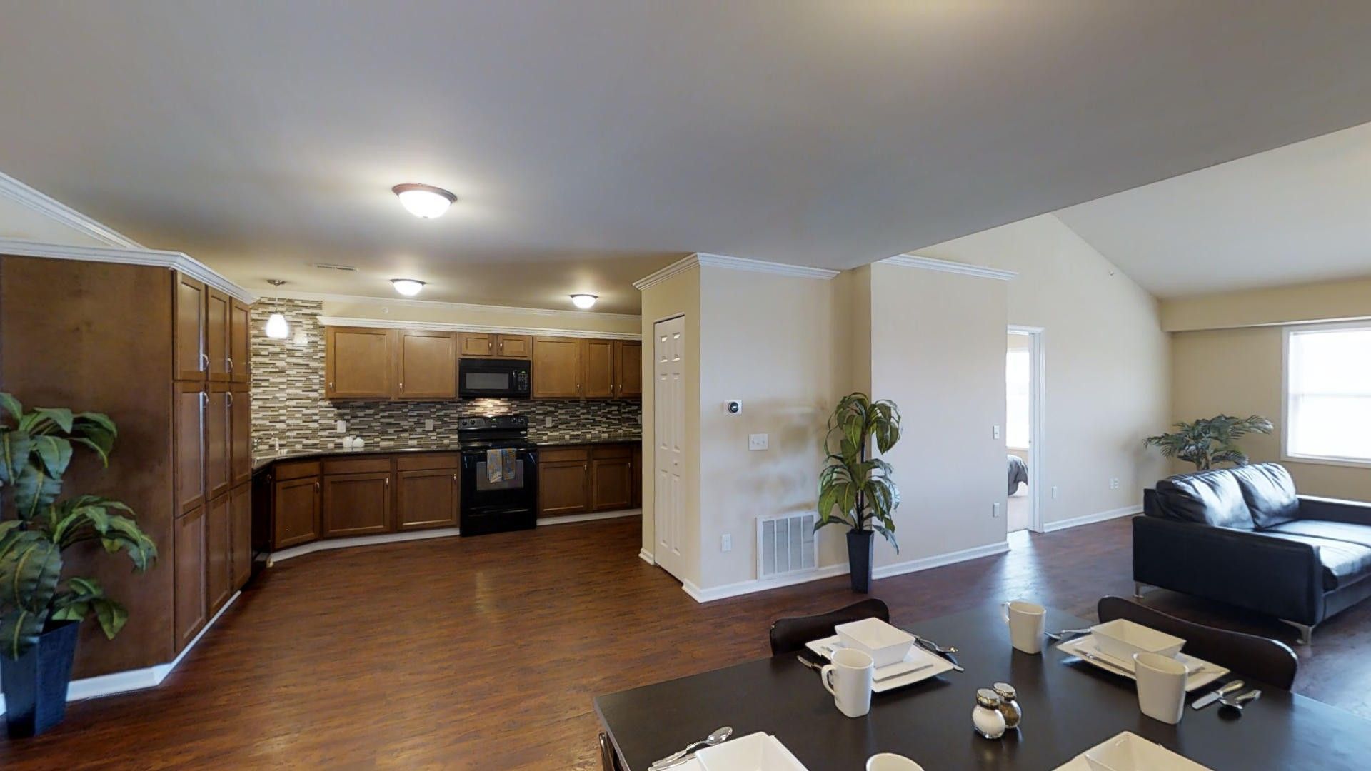A living room with a dining table and a kitchen
