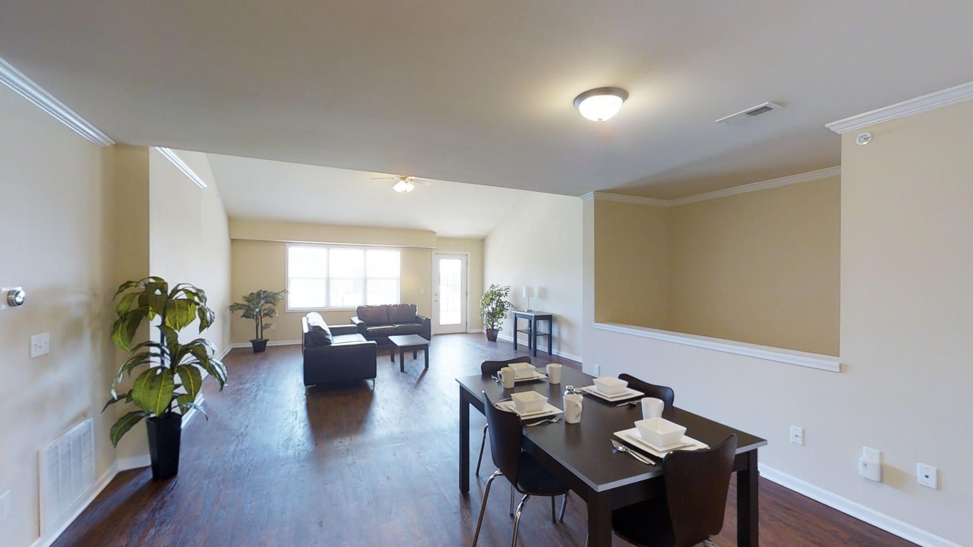 A living room with a dining table and chairs and a couch.
