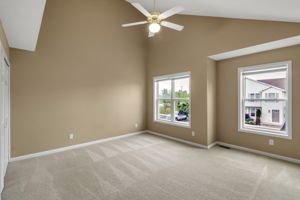 Bright apartment bedroom with ceiling fan and natural sunlight