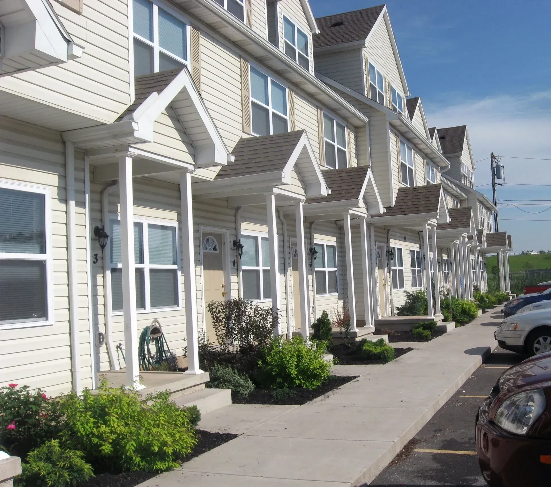 Exterior photo capturing apartment buildings framed by surrounding greenery