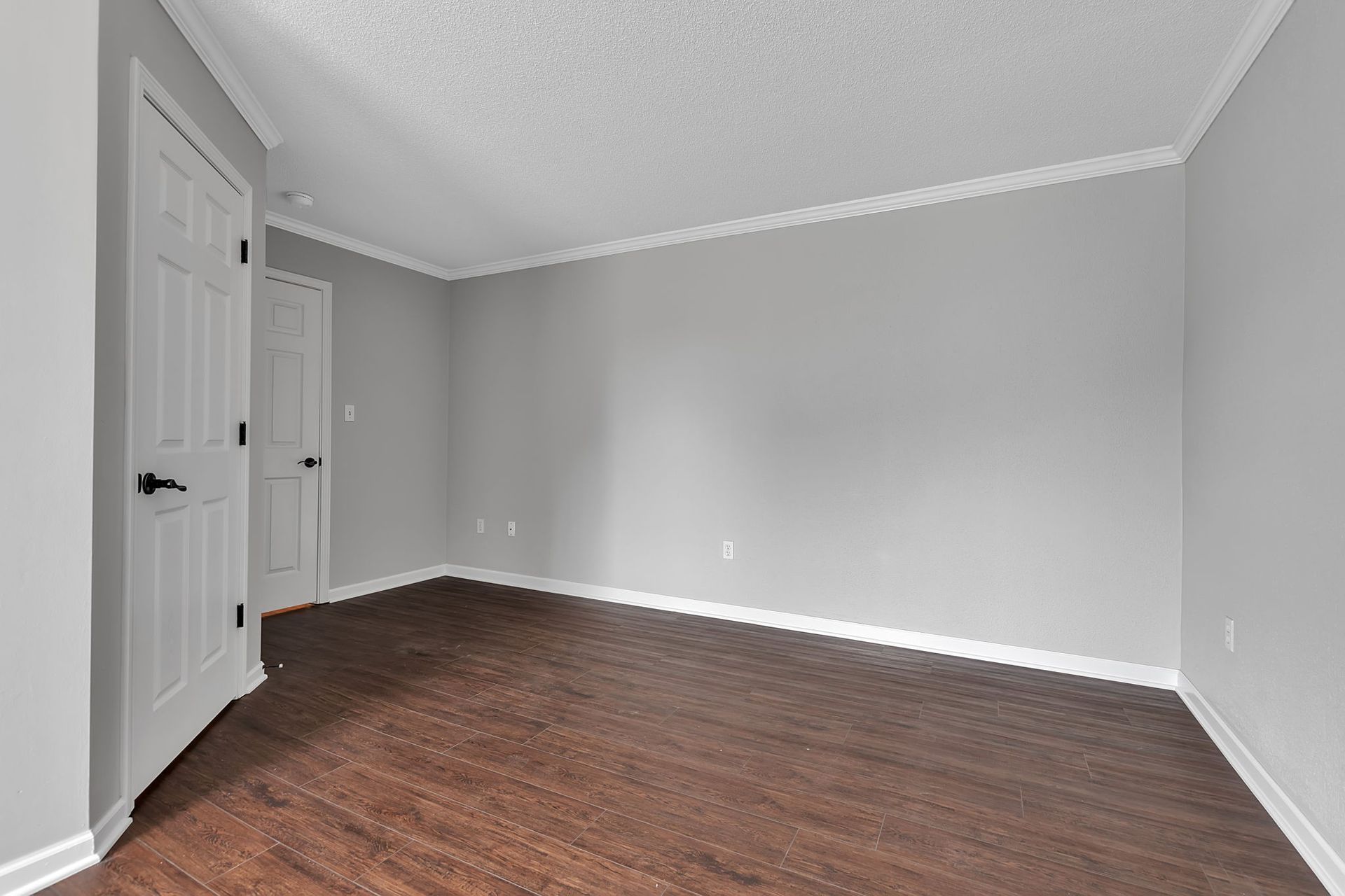 Large bedroom with open floor space and modern trim