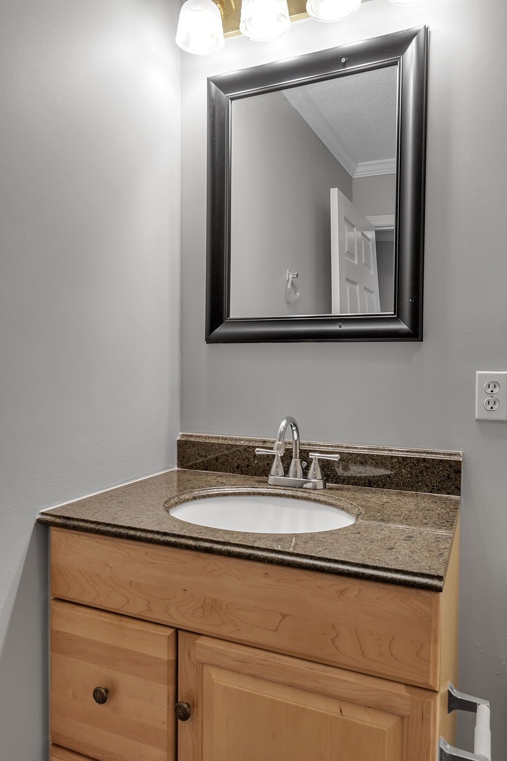 Washroom interior featuring contemporary sink hardware and mirror