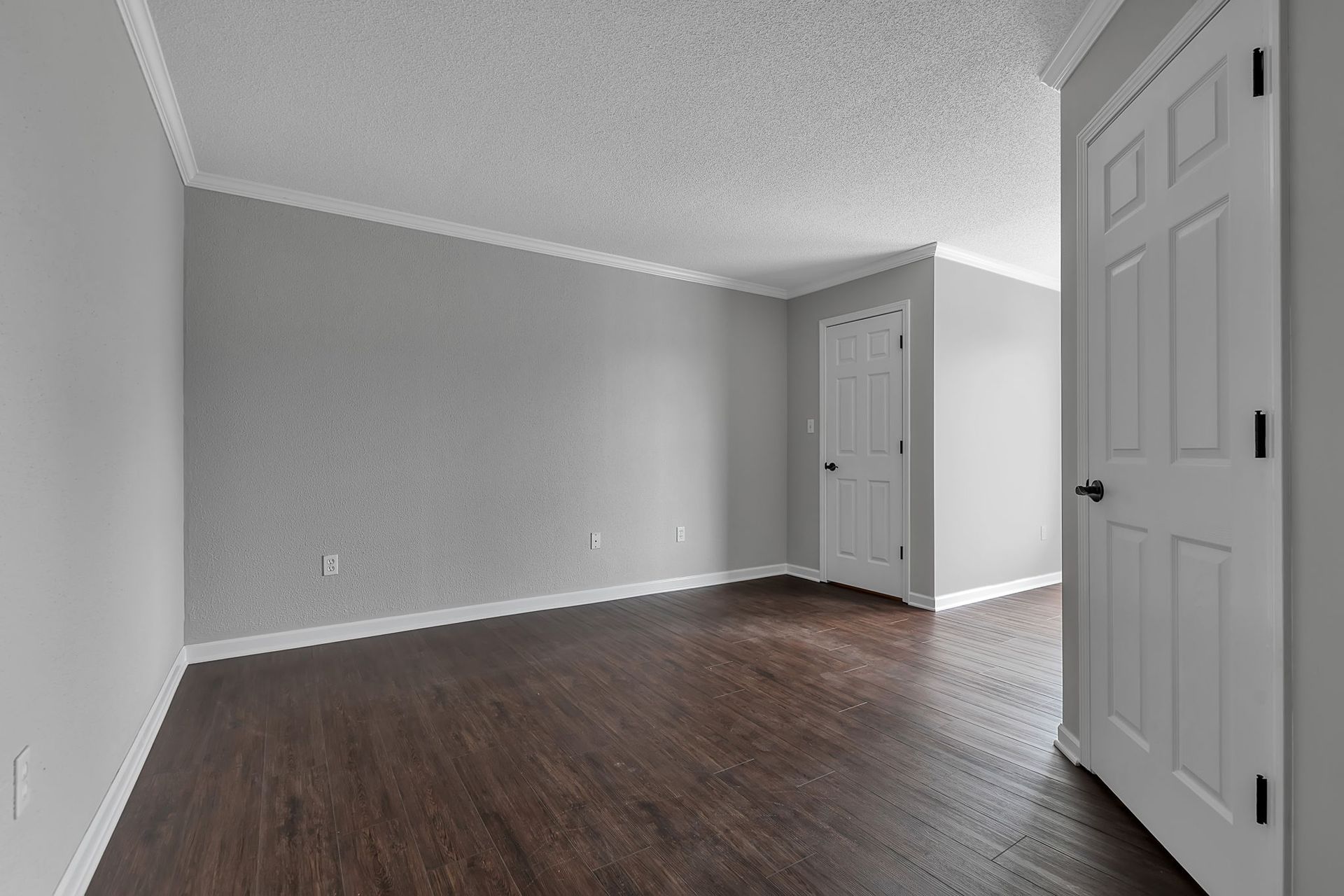 Apartment lounge area featuring wide plank flooring and recessed ceiling lights