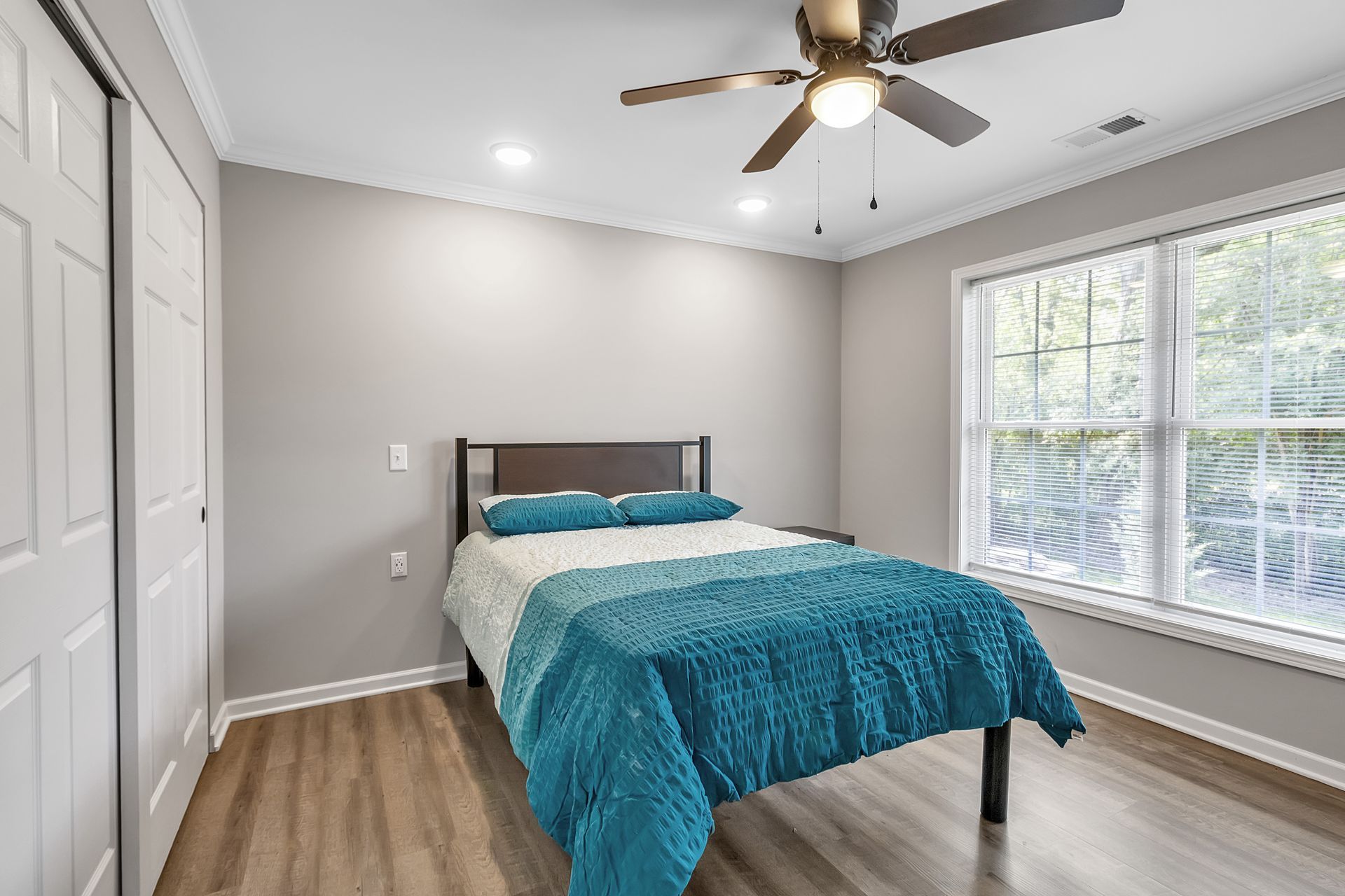 Bedroom space with contemporary flooring and smooth wall finish