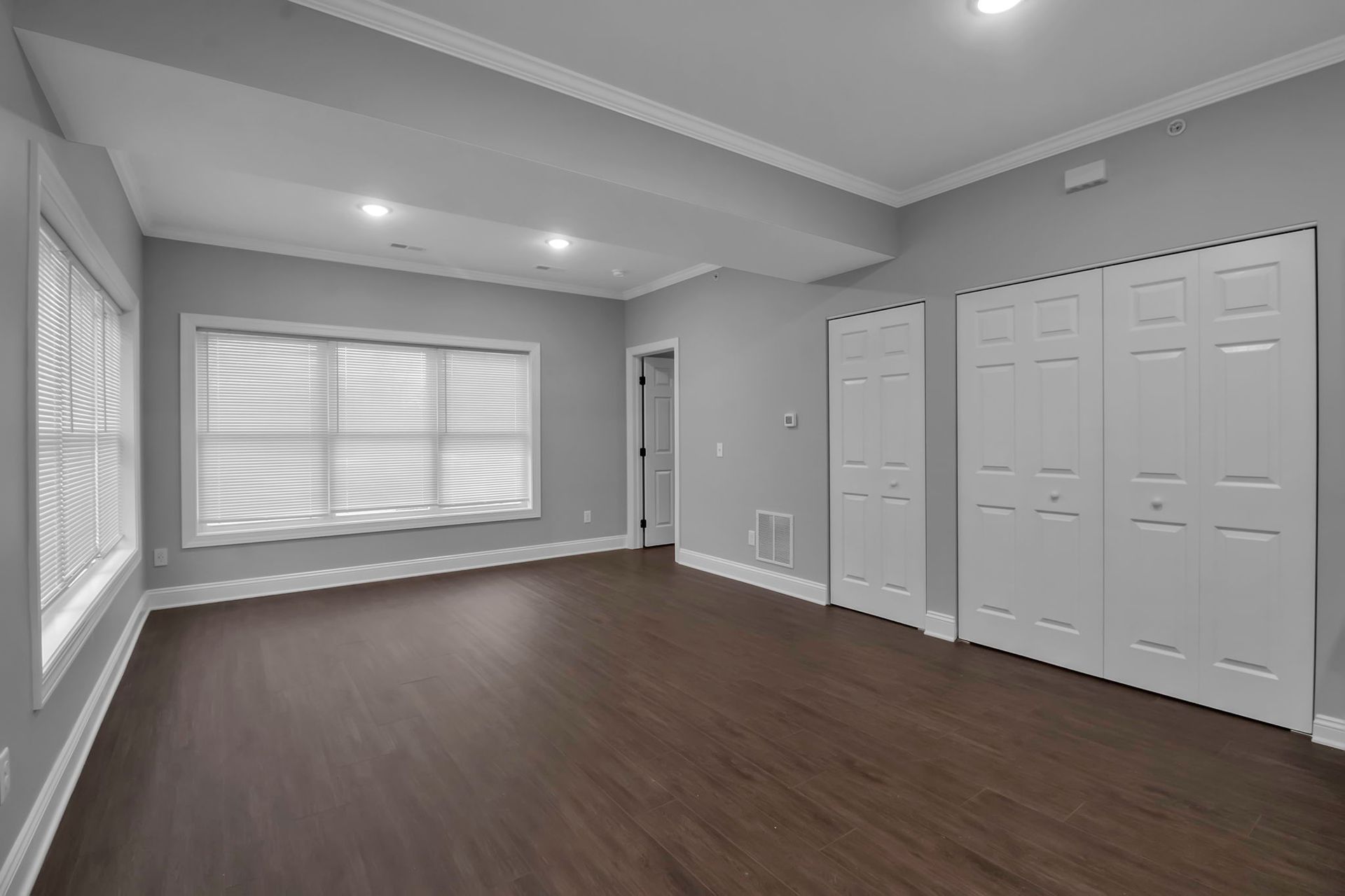 Spacious bedroom with ceiling fan and natural light