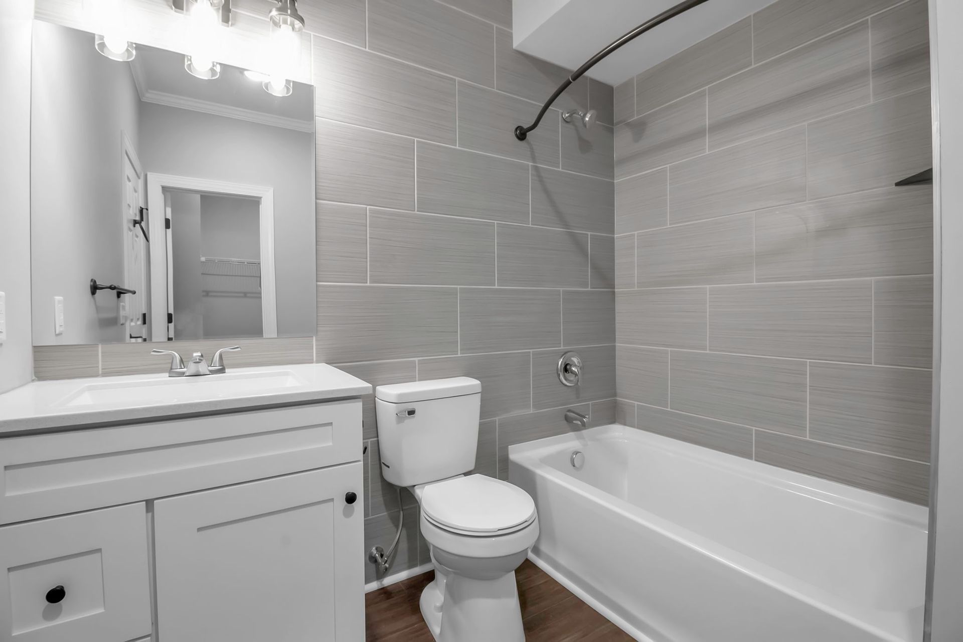 Clean bathroom with tile shower wall and bathtub