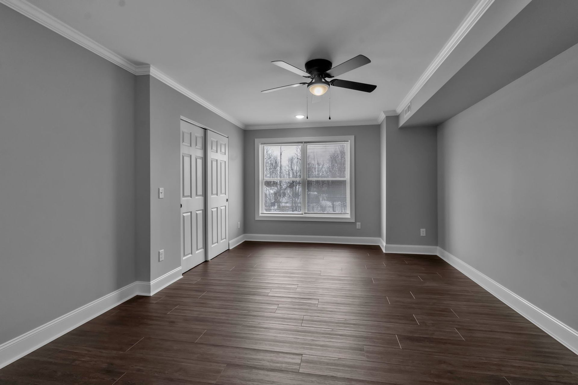 Apartment bedroom with natural light and ceiling fan