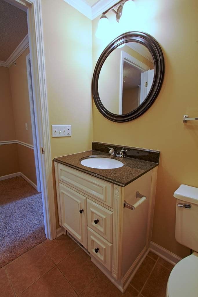 A bathroom with a sink , toilet and mirror.