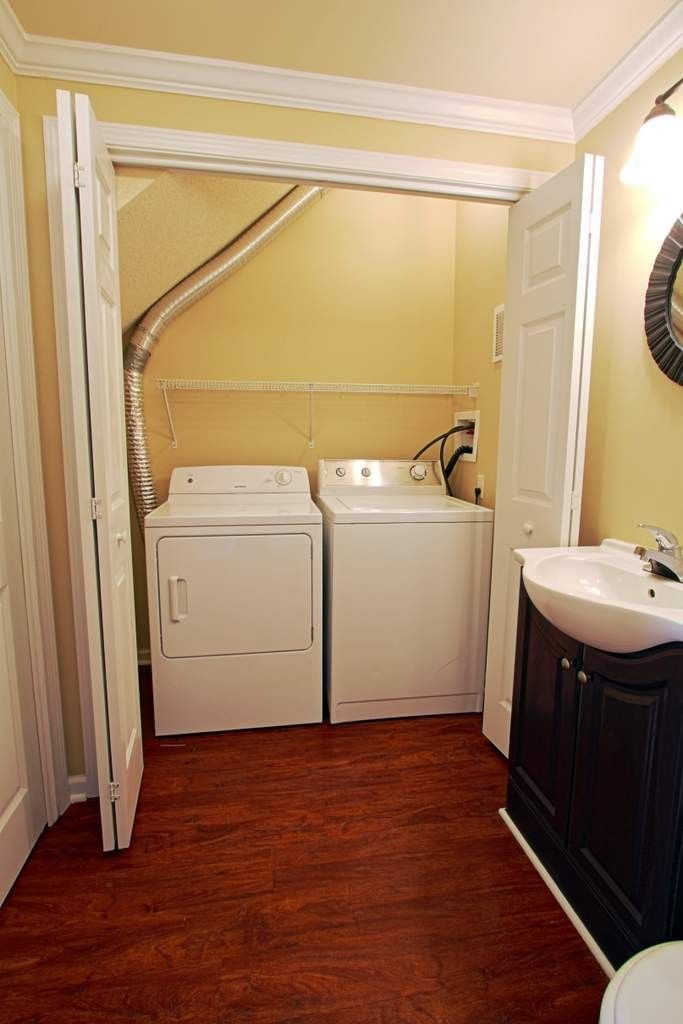A laundry room with a washer and dryer and a sink