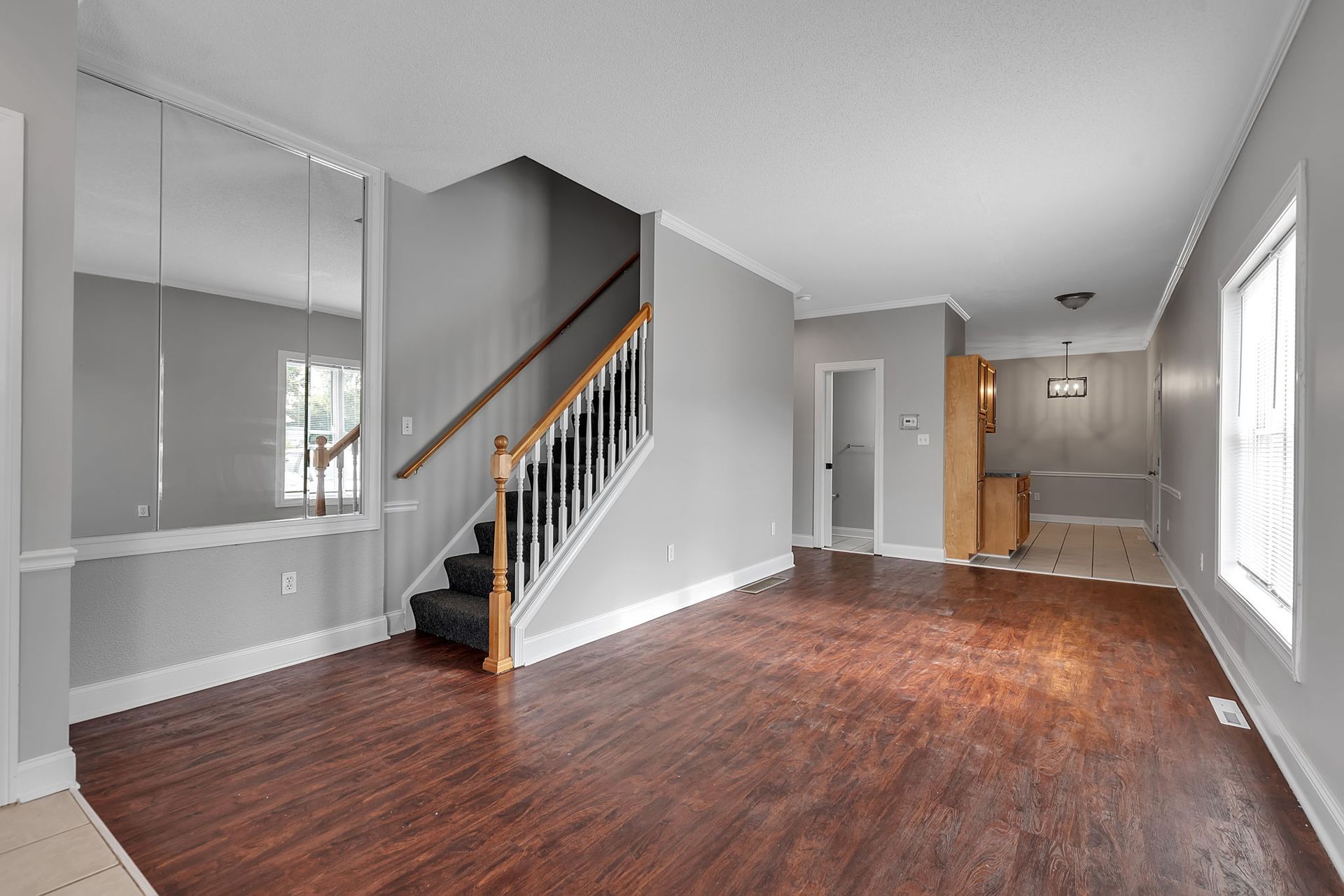 Bright apartment living room with large window and wood flooring