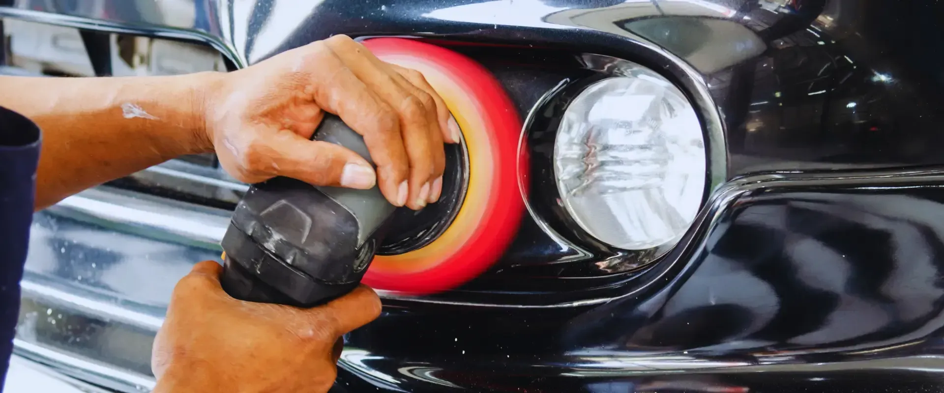 A person is polishing a car with a polisher.