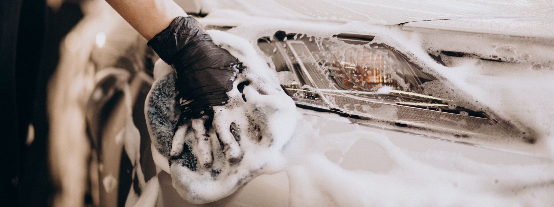 A person is washing a car with soap and water.
