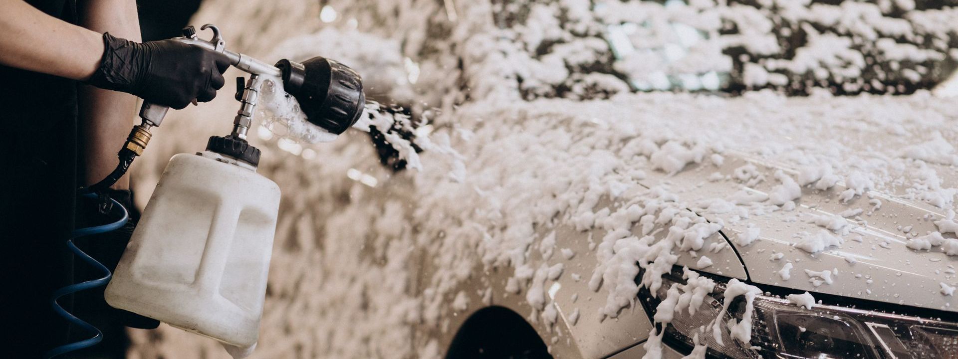 A person is washing a car with foam.