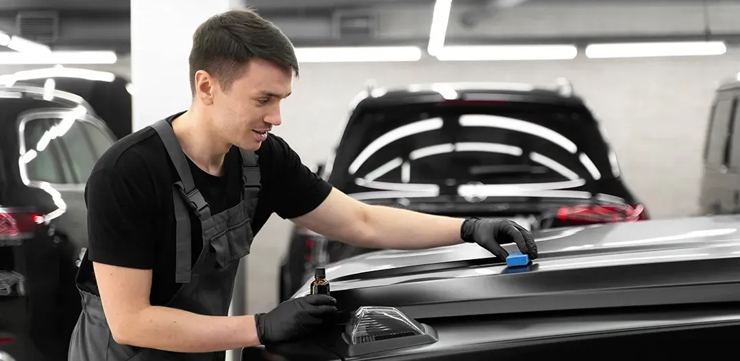 A man is working on a car in a garage.