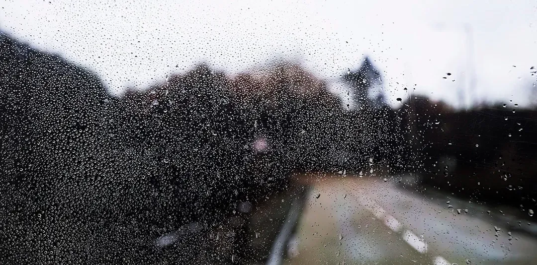 A close up of a window with rain drops on it.