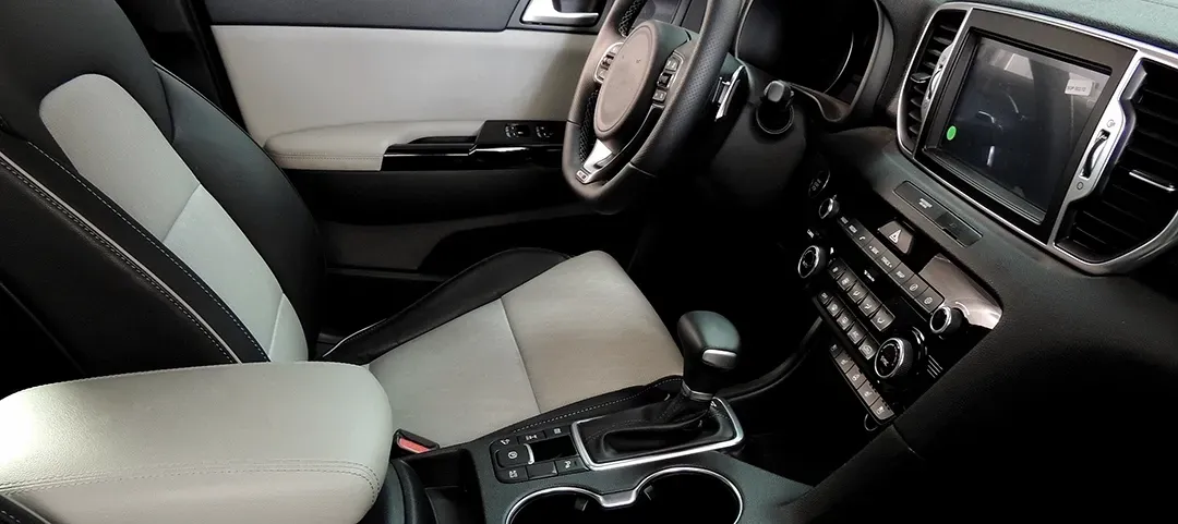The interior of a car with a steering wheel and a dashboard.