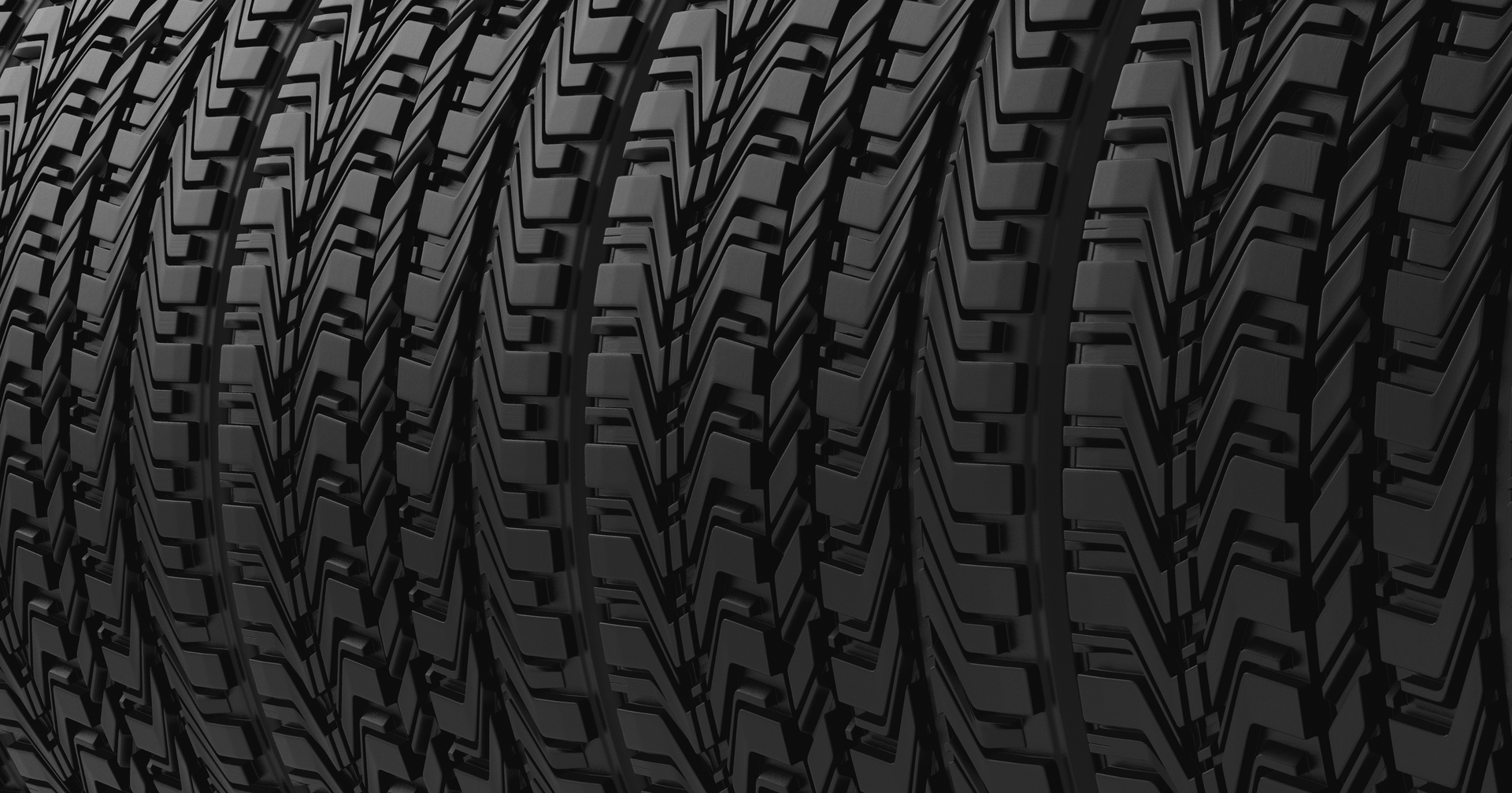 Close-up of stacked black car tires with deep tread patterns