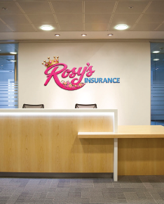 Insurance office reception desk with a pink logo sign on the back wall