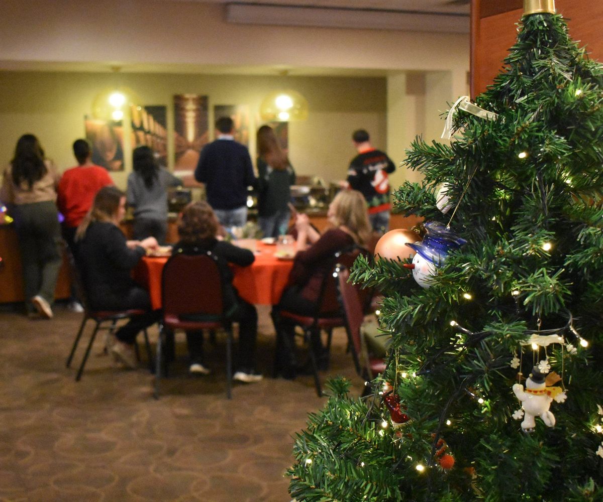 A company holiday party in Suite 28 at Zone 28 in Pittsburgh, with red linens and a lit Christmas tree