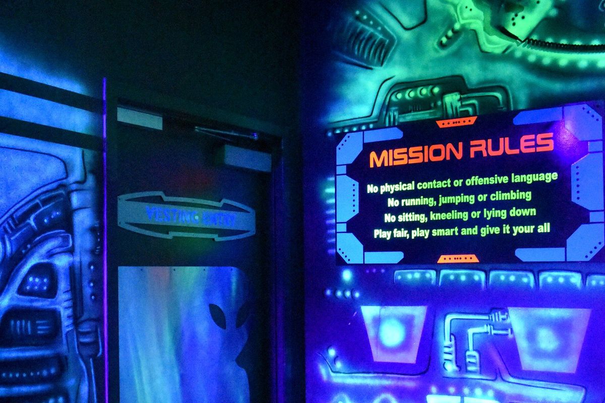 The blacklit vesting room at Area 28 laser tag in Zone 28, Pittsburgh, with the Mission Rules board