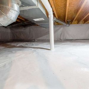 Crawlspace with white vapor barrier, exposed wooden joists, ductwork, and a central support pipe