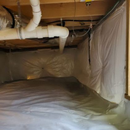 Crawlspace lined with white plastic sheeting and exposed ductwork overhead.