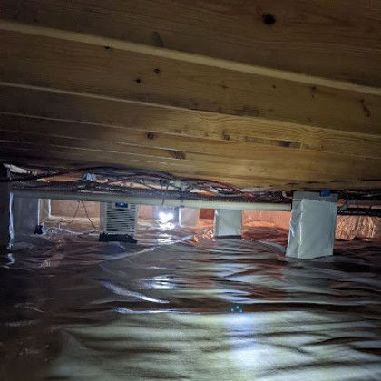 Insulated crawlspace under floor joists with reflective vapor barrier and support blocks