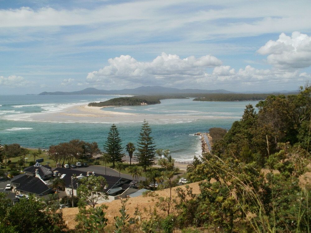 A Grassy Hillside With Trees And Mountains In The Background — Caba's Drapery In Nambucca Heads, NSW