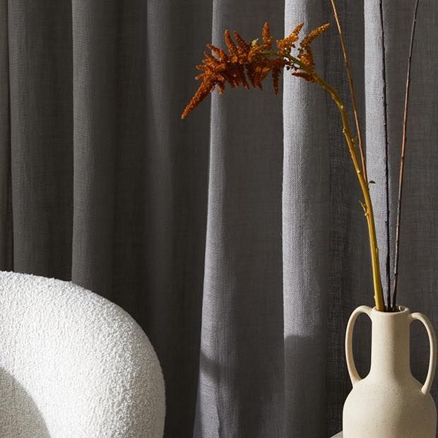 A Vase With Flowers In It Next To A Chair — Caba's Drapery In Coffs Harbour, NSW