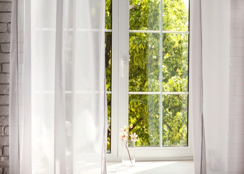 A Window With White Curtains And A Vase Of Flowers In Front Of It — Caba's Drapery In Coffs Harbour, NSW