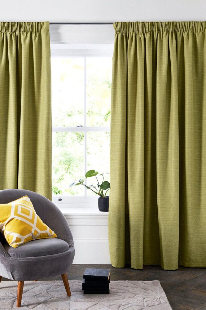 A Living Room With A Chair And A Window With Green Curtains — Caba's Drapery In Coffs Harbour, NSW