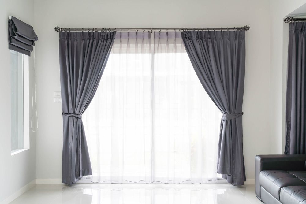 A Living Room With Sliding Glass Doors And Gray Curtains — Caba's Drapery In Coffs Harbour, NSW