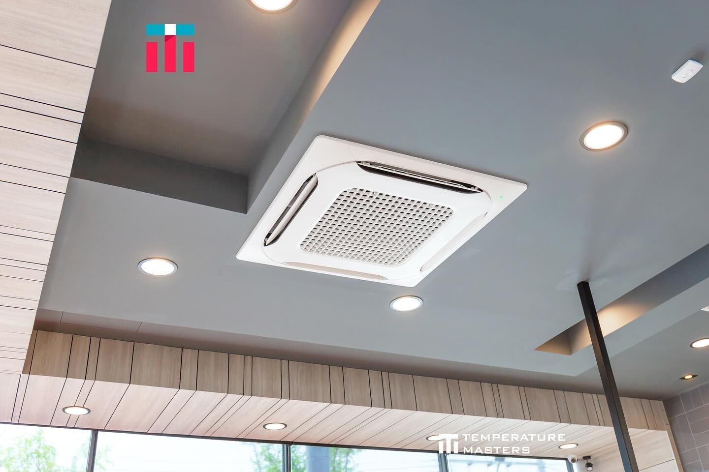 Ceiling with white air-conditioning vent and recessed lights in a modern indoor space