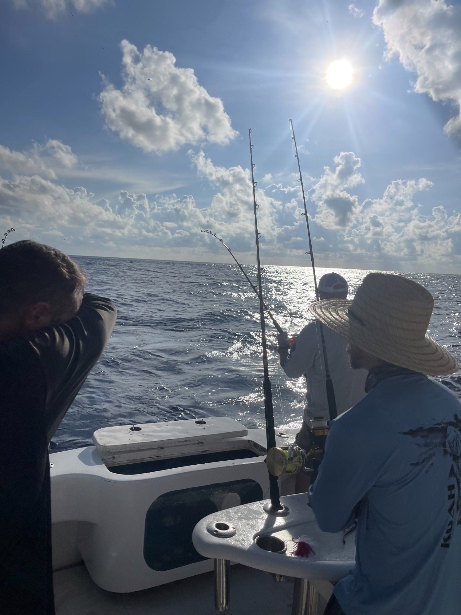 Two men are fishing on a boat in the ocean.