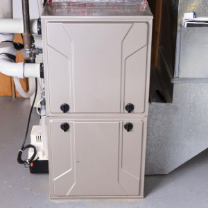 Beige furnace with attached white ducts and metal venting in a basement or utility room