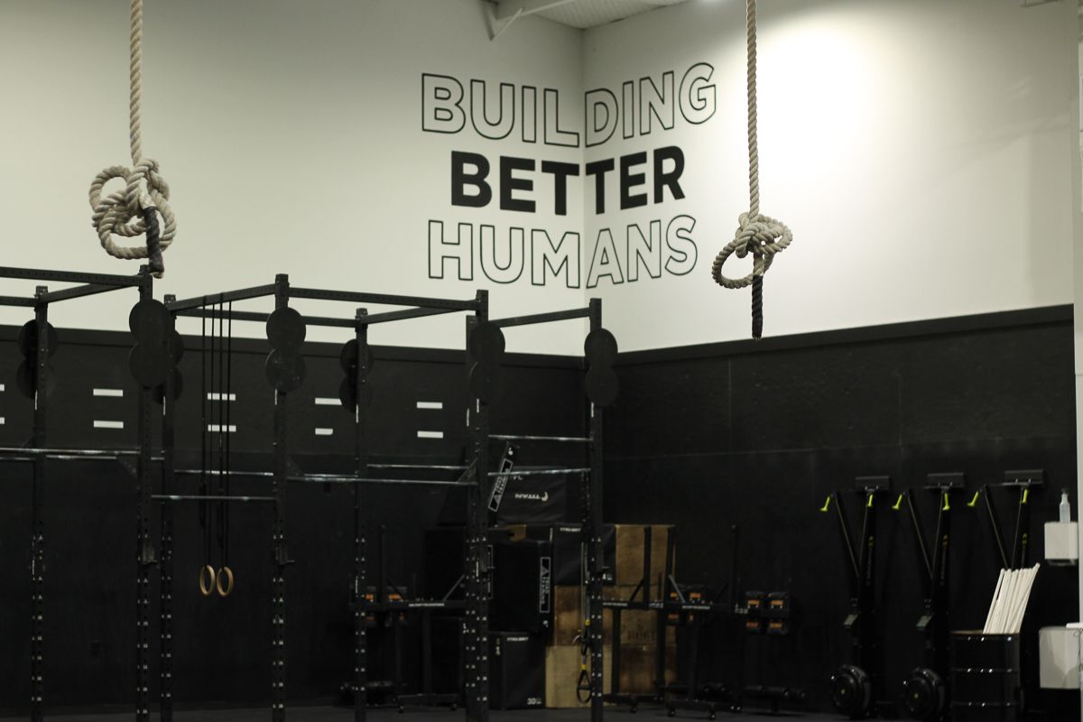 Gym interior with black equipment, white walls, and text