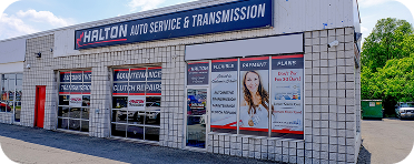 A white brick building with a blue sign that says halton auto service and transmission | Halton Auto Service & Transmission