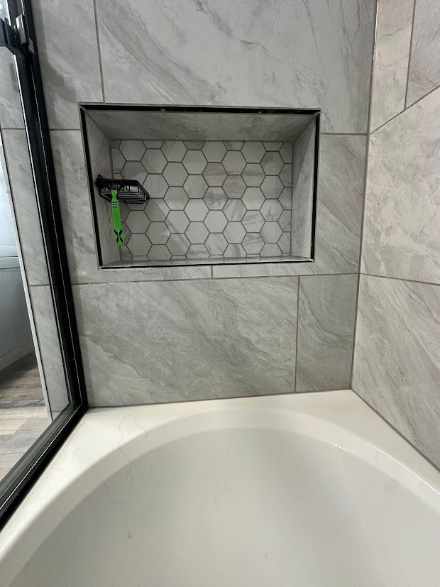 Bathroom with bathtub, tiled walls, and a recessed shelf.