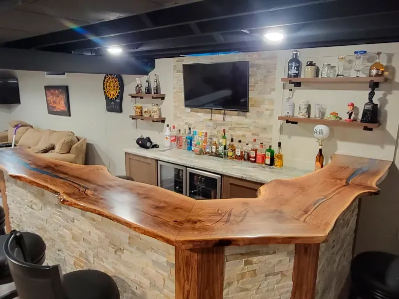 A basement bar with a wooden counter top and a television.